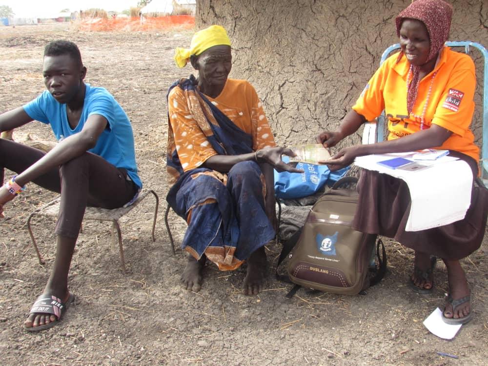 Francis’ grandmother receiving cash on his behalf- Photo courtesy WOCO Kodok IDPs camp